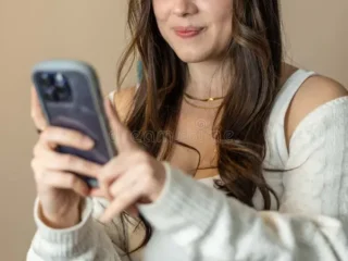 young-beautiful-woman-sitting-home-using-her-phone-portrait-social-media-apps-373969262-2